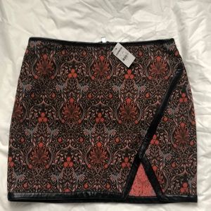 Express mini skirt. Multi color/black leather piping. Back zip. Slit in front.